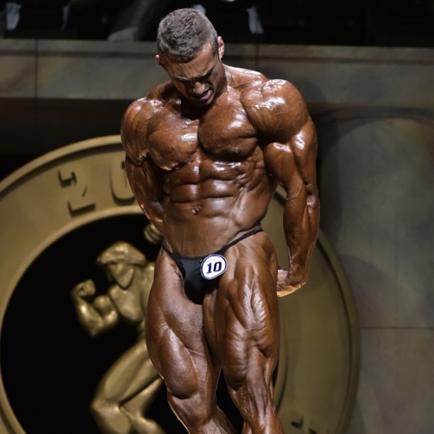 Cody Montgomery posing on a bodybuilding stage, looking big and muscular