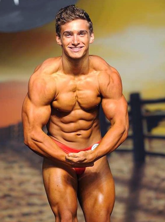 Cody Montgomery posing on a bodybuilding stage as a teen looking muscular and lean
