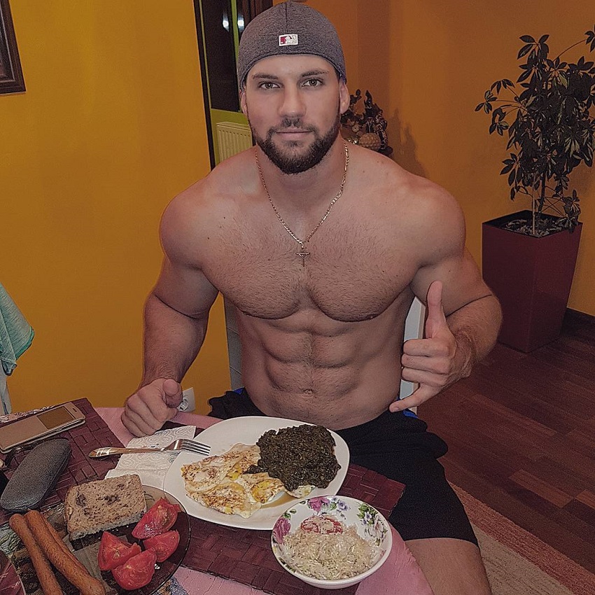 Florian Munteanu sitting shirtless having a meal