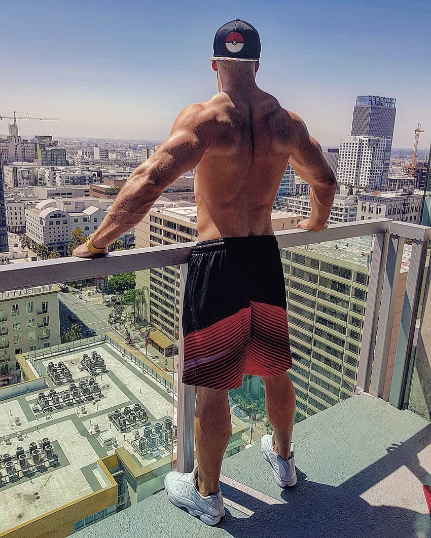 Florian Munteanu standing on a balcony overlooking a big city with skyscrapers during the sunny day