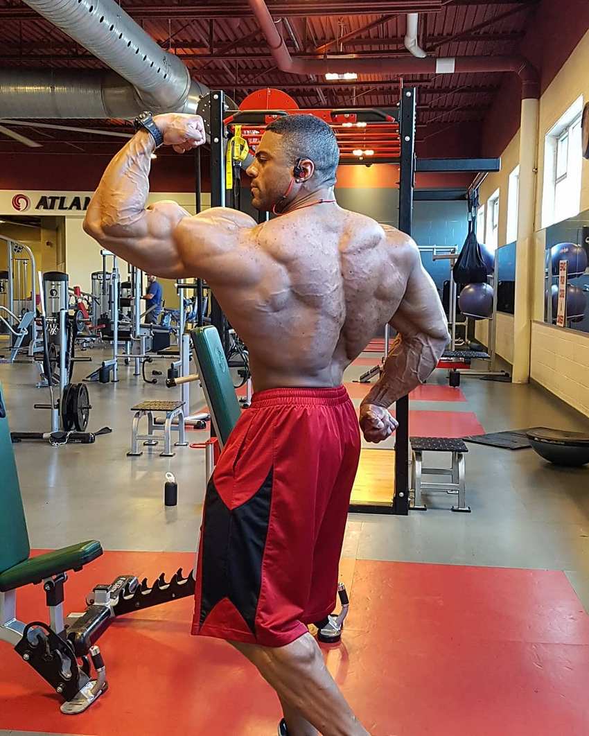 Henri-Pierre Ano flexing his back and biceps for the camera