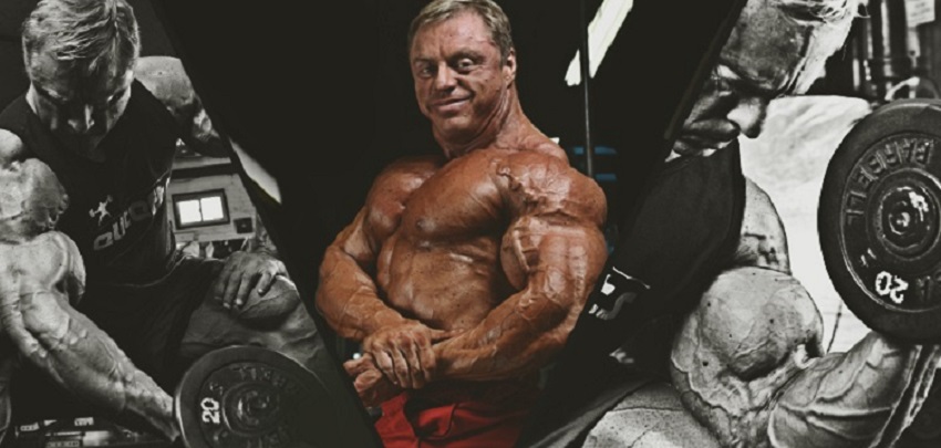 John Meadows doing a side chest pose looking big ripped and fit