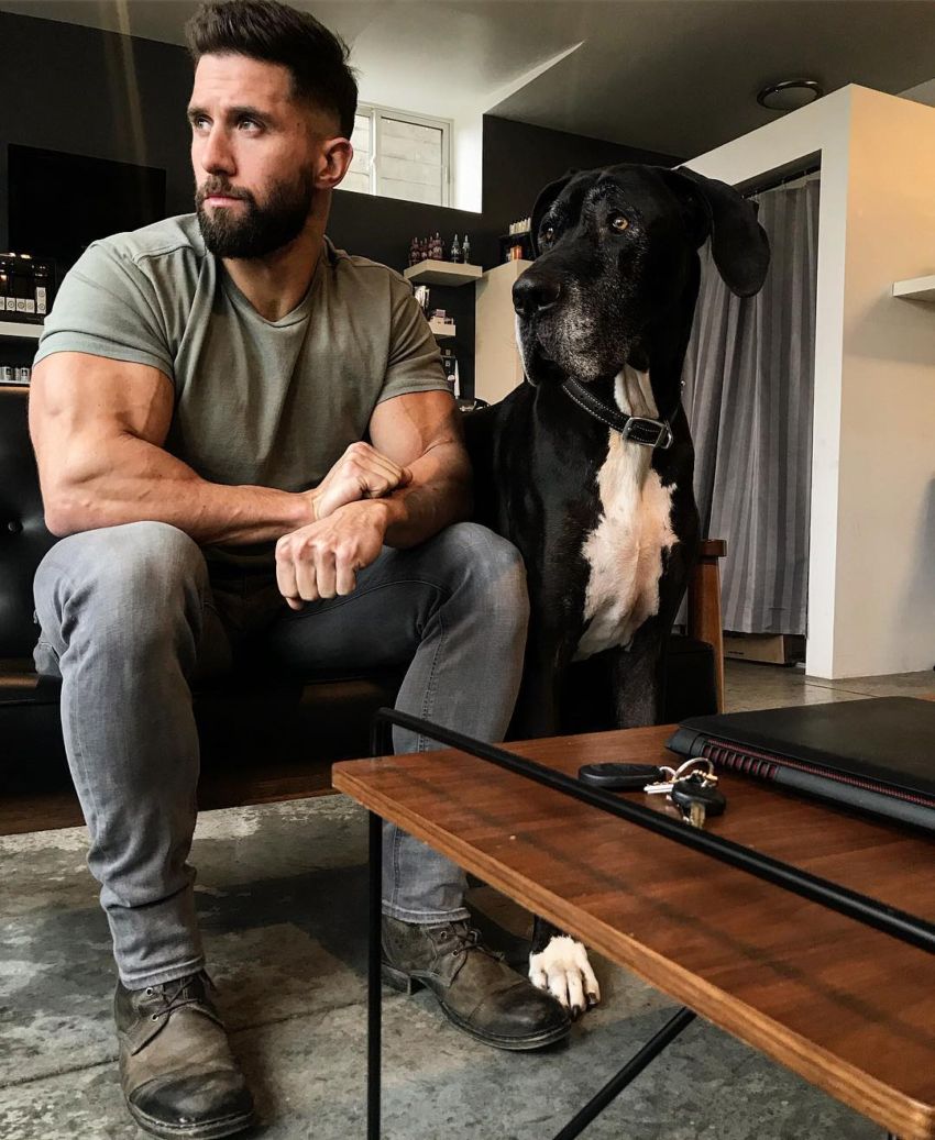 Julian Smith with his dog in his house, looking in the distance, looking healthy and fit