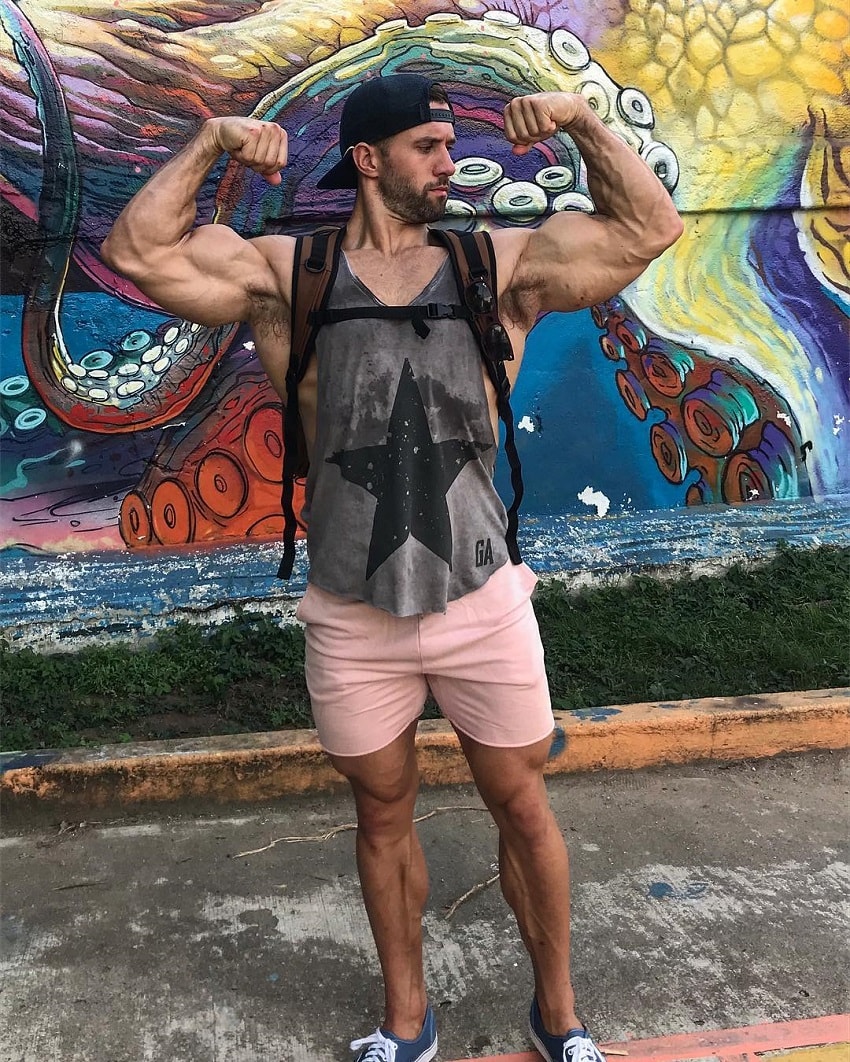 Julian Smith flexing his ripped and muscular arms for a photo