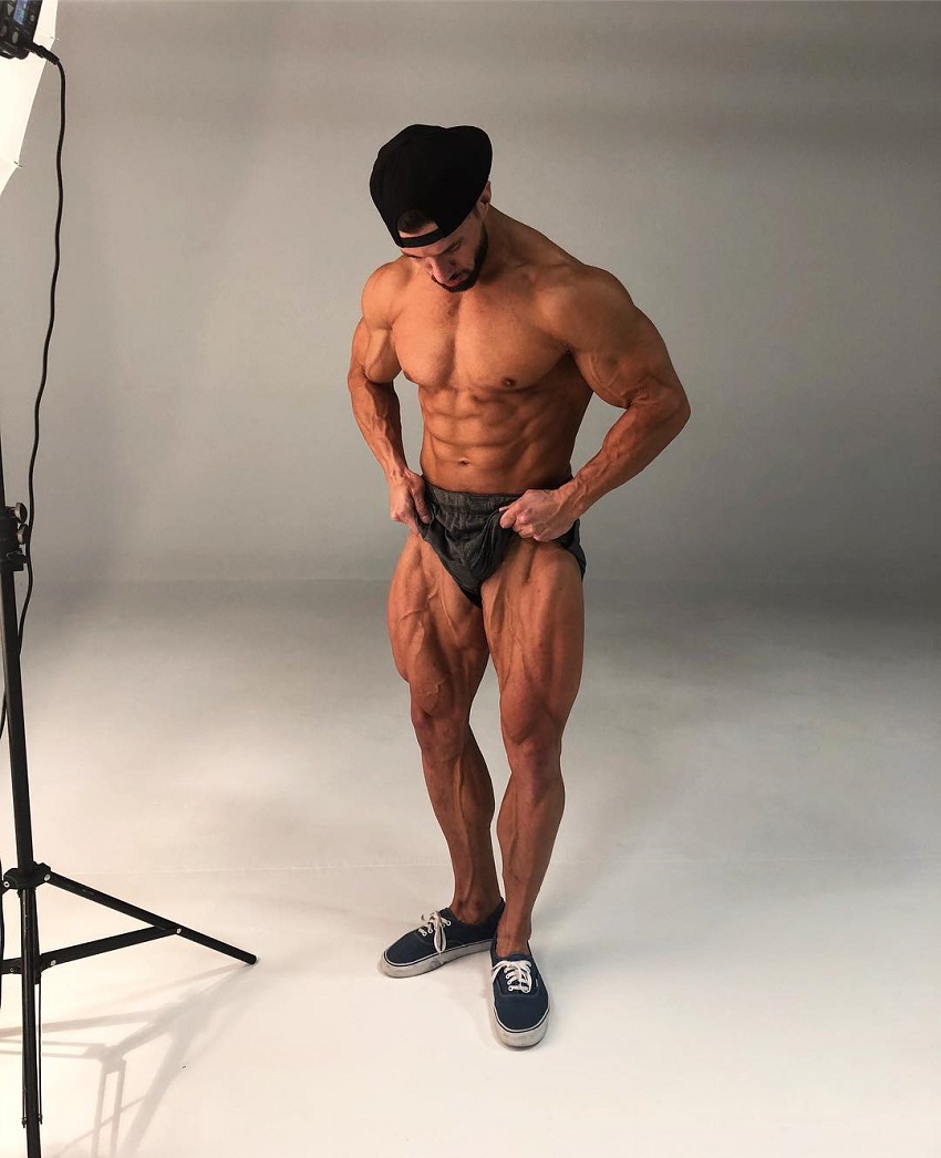 Julian Smith doing a photoshoot posing shirtless looking ripped