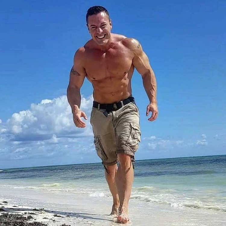 Micah Lacerte enjoying the sun on the beach and smiling for a photo