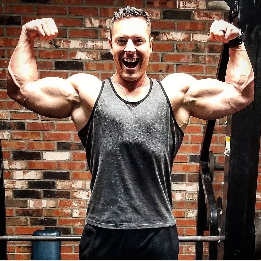 Micah Lacerte flexing his biceps and smiling for a photo