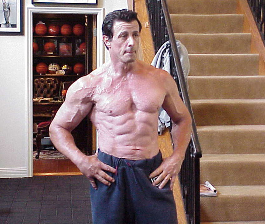 Sylvester Stallone posing at home topless looking ripped and muscular