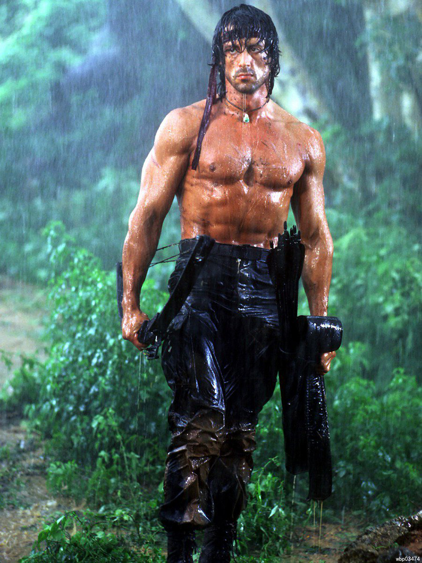 Sylvester Stallone in Rambo standing in the rain looking lean and strong