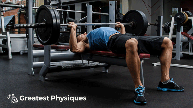 Athletic man performing bench press exercise