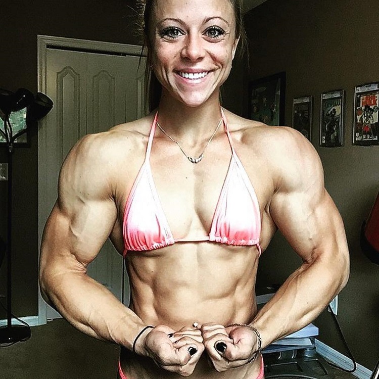 Dani Reardon flexing her muscles for a photo wearing a bikini