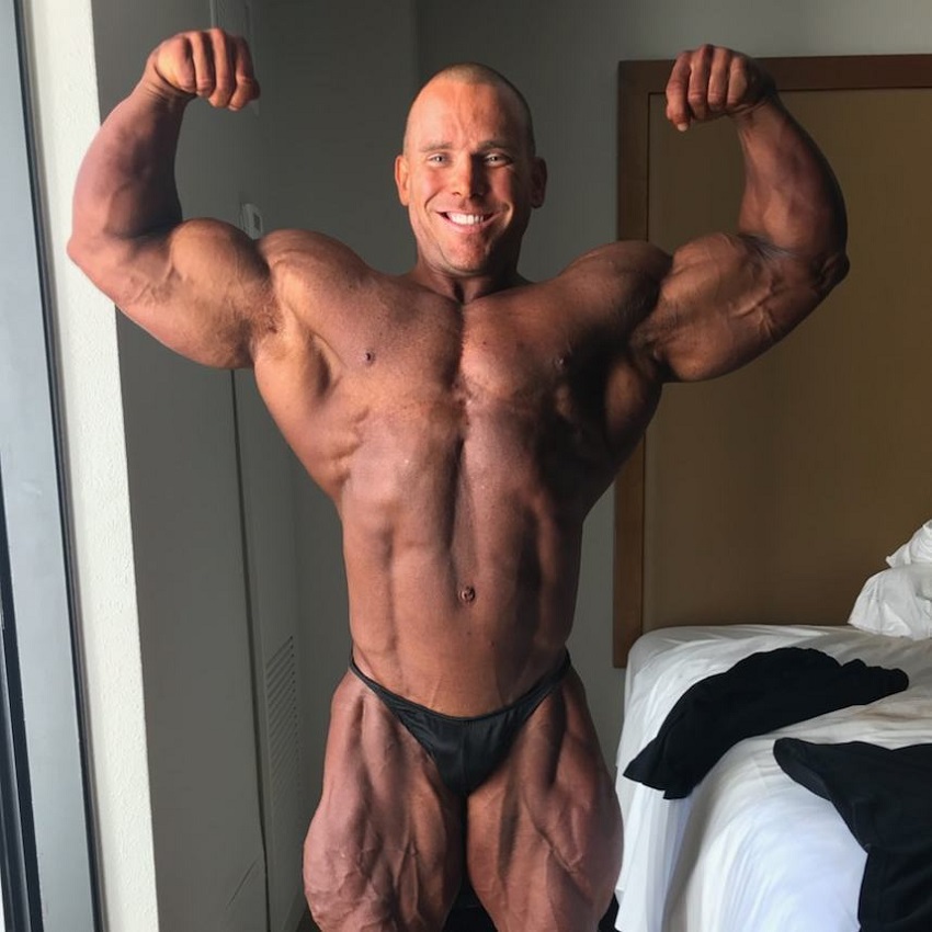 Jordan Janowitz doing a front double biceps pose in his room looking conditioned