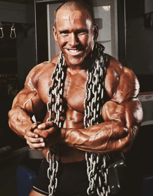 Jordan Janowitz posing shirtless with big chains around his neck looking muscular