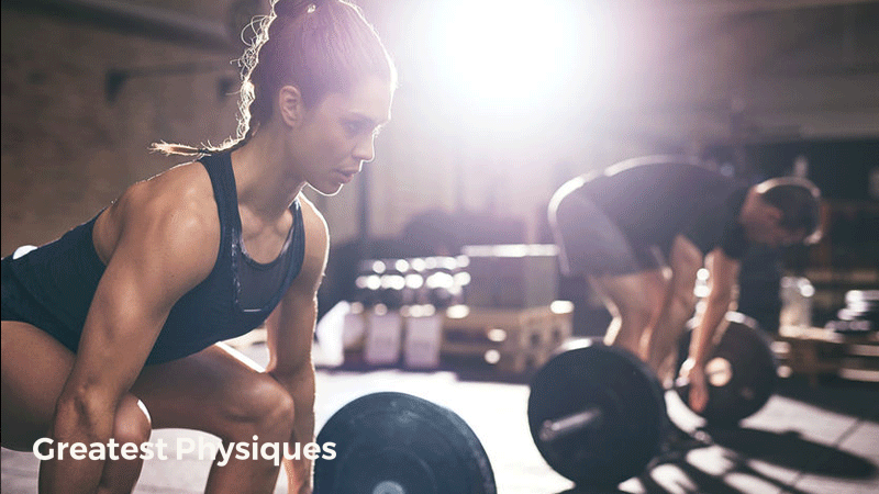 Fit man and woman in a gym lifting barbells