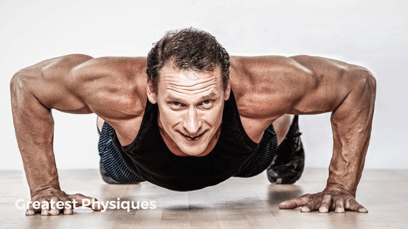 Older man performing press-ups on a wooden floor