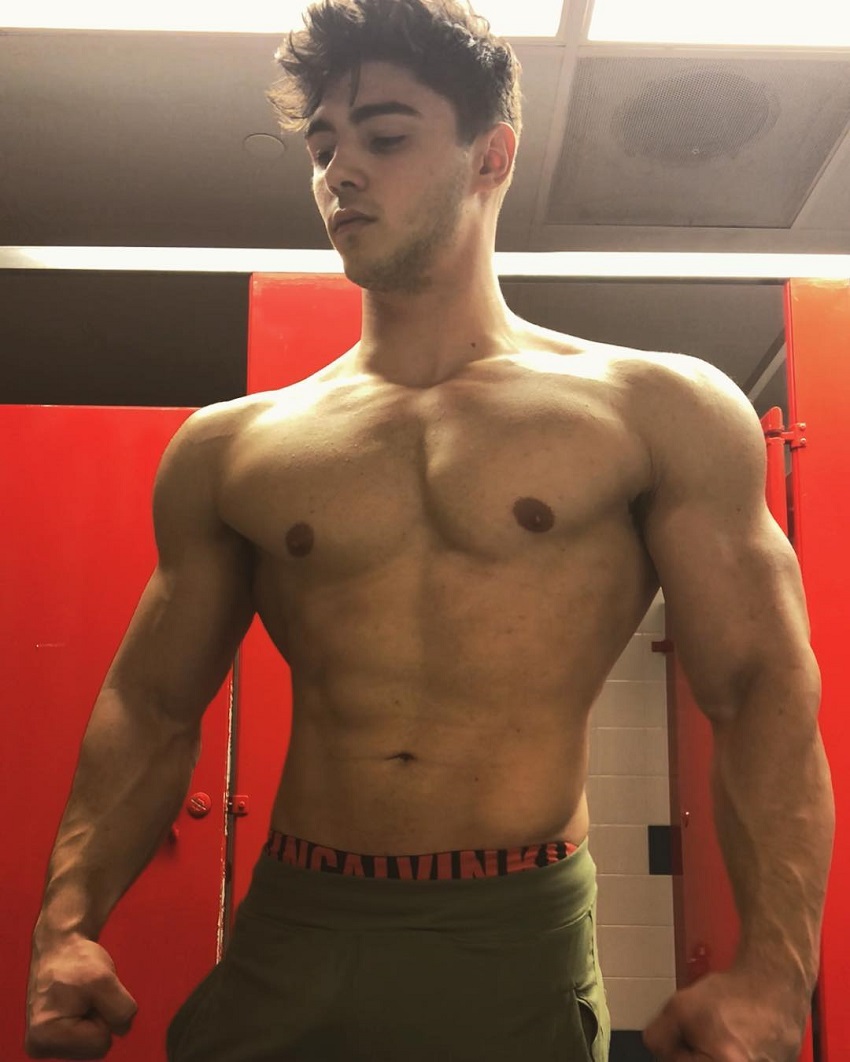 Qwin Vitale posing shirtless for a photo his arms and chest looking chiseled and abs ripped