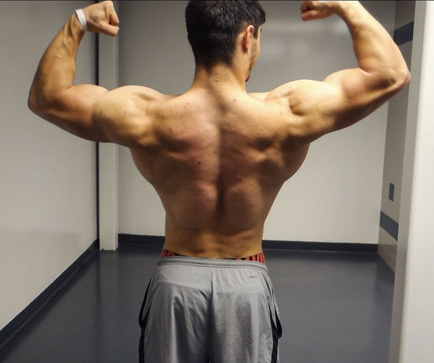 Qwin Vitale doing a back double biceps flex looking ripped and muscular