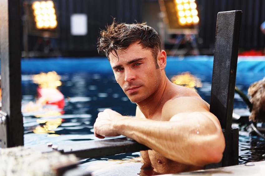 Zac Efron posing for a photo while standing in a pool