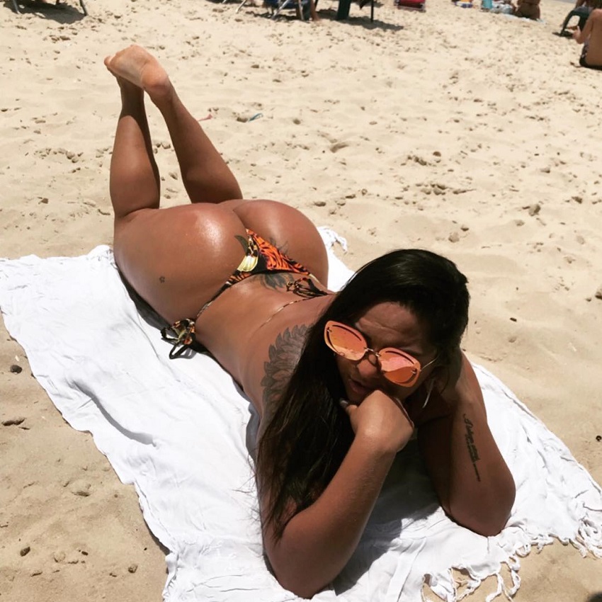 Andressa Soares lying on a towel on a beach looking curvy and lean