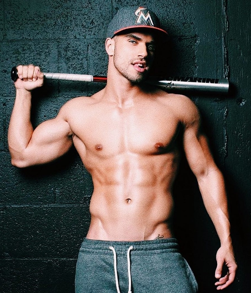 Darian Alvarez posing shirtless with a sledgehammer in his hand