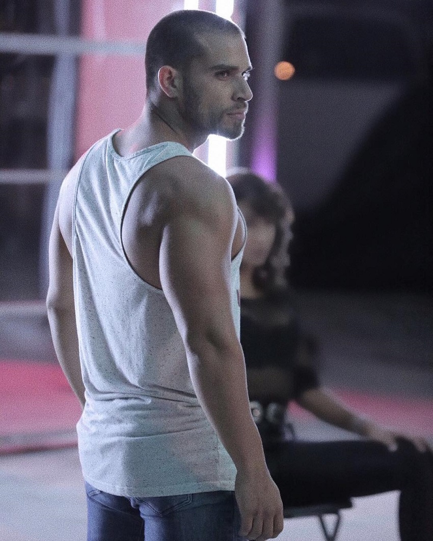 Darian Alvarez posing in his white tank top looking fit and lean