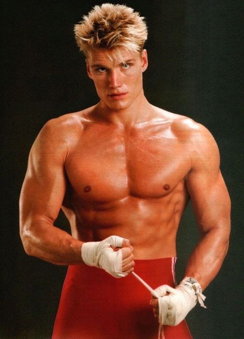 Dolph Lundgren posing for a photo wrapping his hands for a boxing match, looking strong and ripped