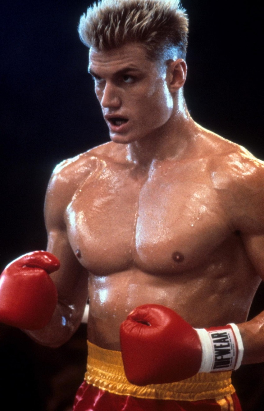 Dolph Lundgren shirtless wearing his boxing gloves, playing as Ivan Drago in Rocky IV, looking ripped and big