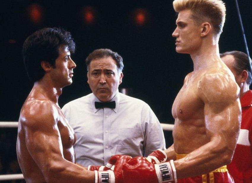 Dolph Lundgren standing in the boxing ring with Sylvester Stallone, looking into each others eyes before the beginning of the fight