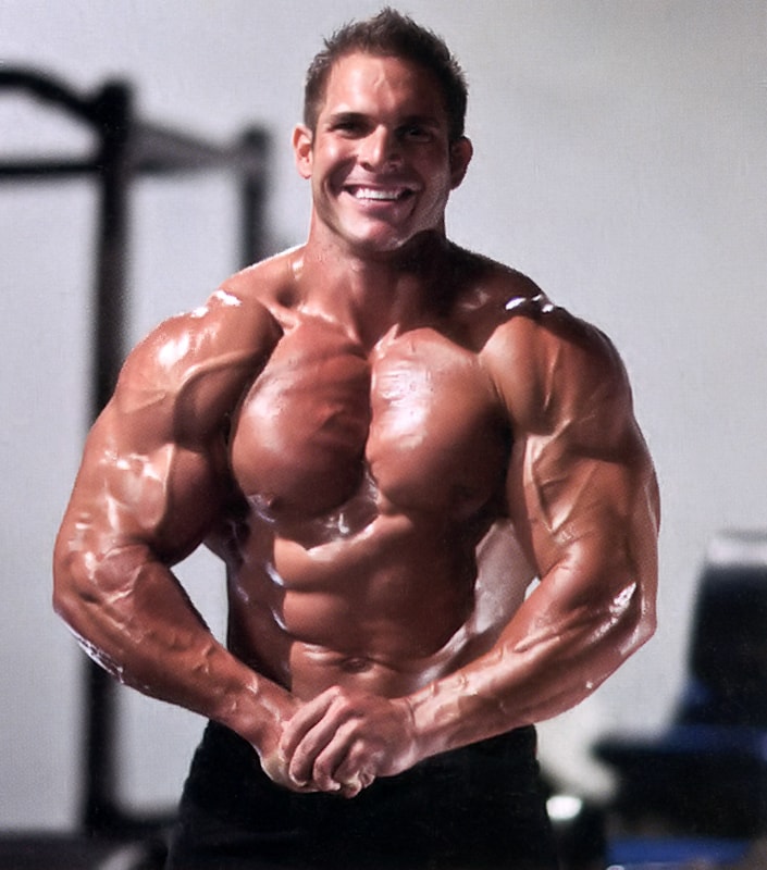 Josh Bergeron doing a shirtless most muscular pose in a gym