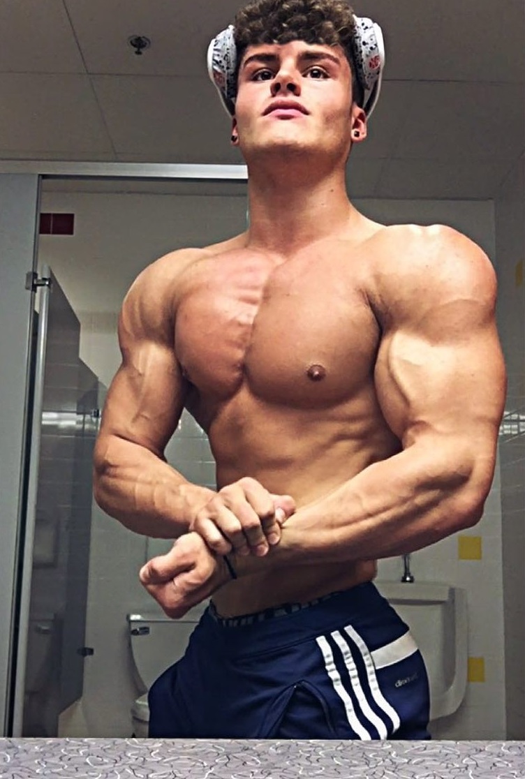 Justin Martilini performing a side chest pose for a photo looking lean and muscular