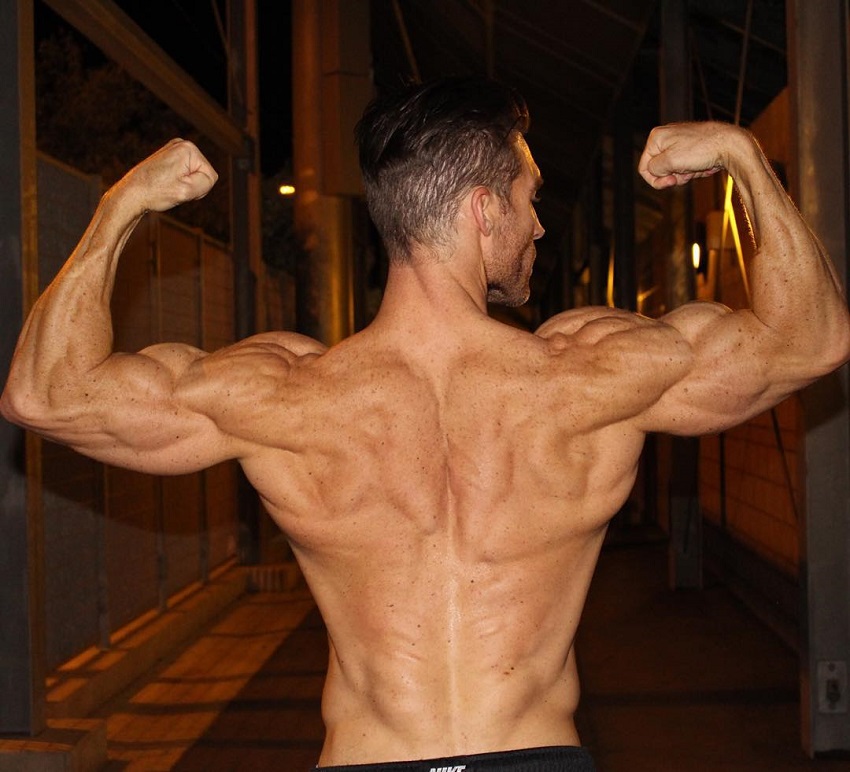 Kyle Clarke doing a back double biceps flex for a photo