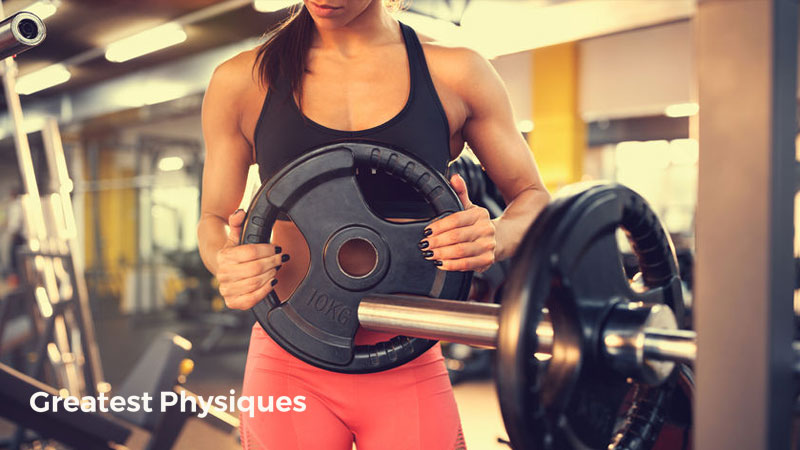 Female weightlifter in pink pants loading a barbell in the gym