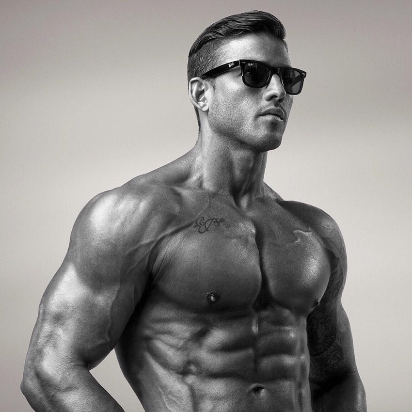 Rob Sharpe posing shirtless with sunglasses on, looking fit and lean