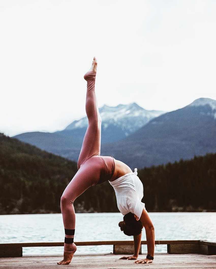 Bianca Cheah doing yoga outdoors in the nature near mountains and a lake, looking fit and healthy