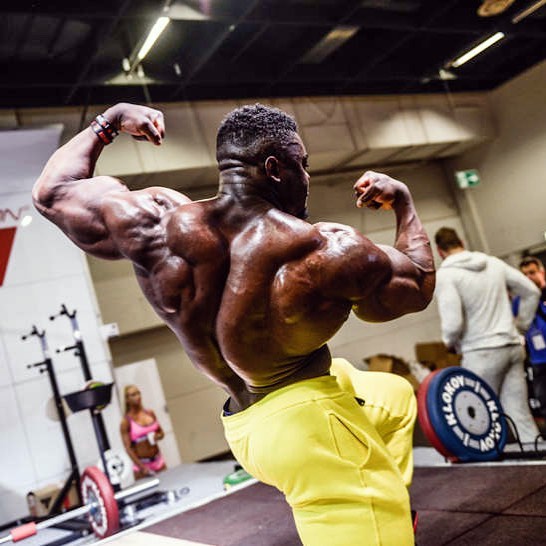 Blessing Awodibu flexing his back and arms in a photo