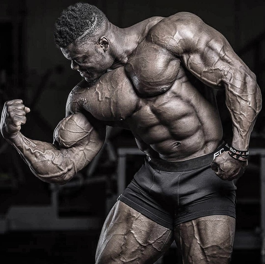 Blessing Awodibu flexing his big and ripped muscles in a professional bodybuilding photo shoot