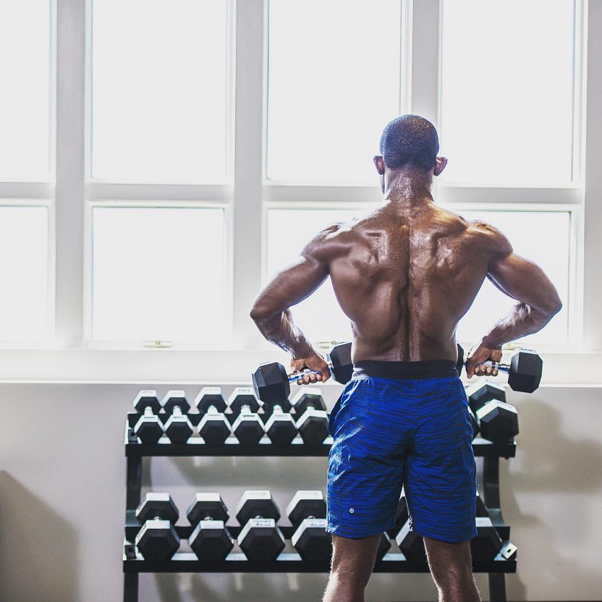 Gideon Akande performing an exercise while shirtless, his back looking ripped and wide