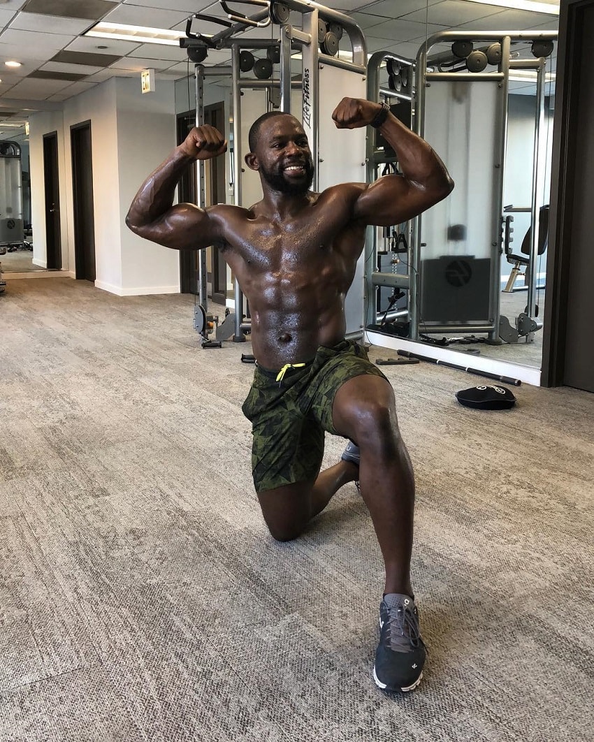 Gideon Akande flexing his shirtless upper body