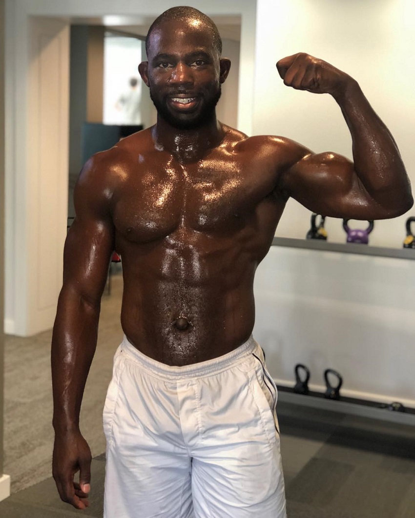 Gideon Akande flexing his biceps and showing off his sweaty and ripped body after a workout