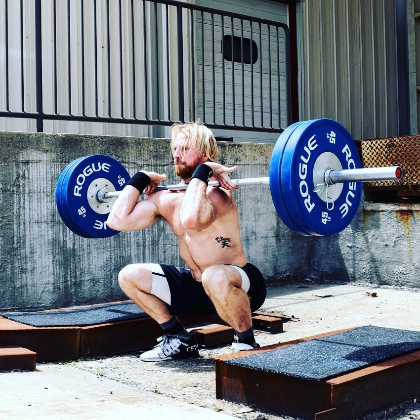 Graham Holmberg lifting a barbell loaded with weights