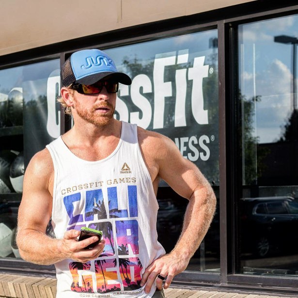 Graham Holmberg standing in front of a CrossFit gym in his summer tank top