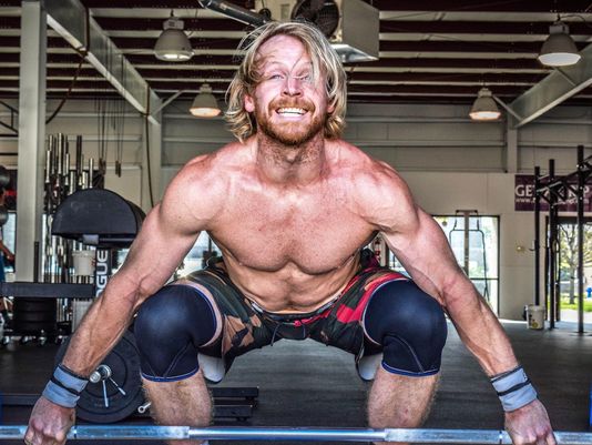 Graham Holmberg lifting a heavy barbell looking fit and lean