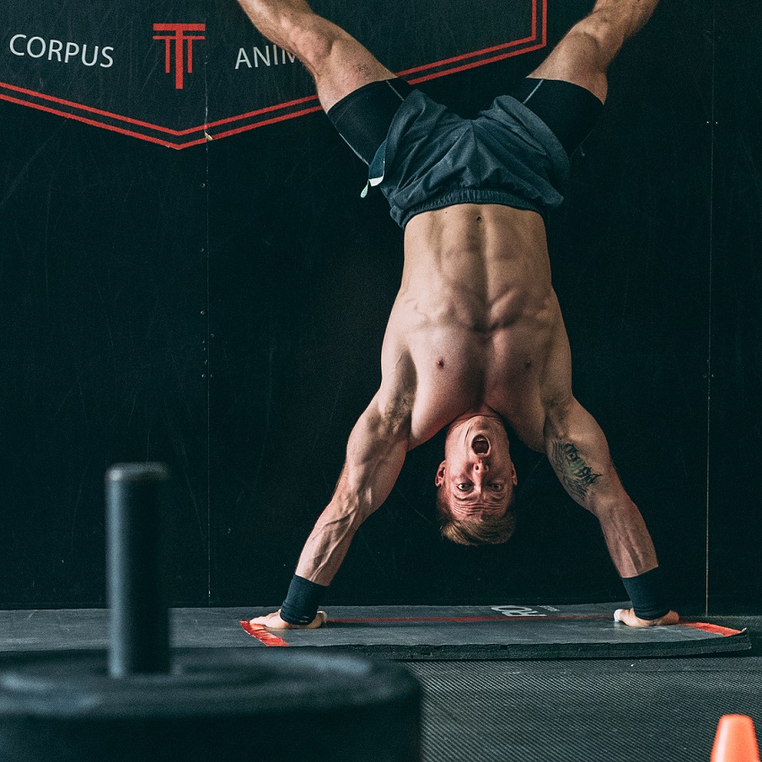 Noah Ohlsen doing a shirtless handstand