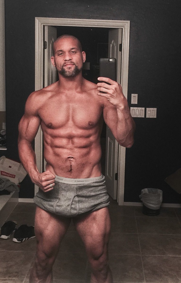 Shaun T taking a selfie of his strong and ripped physique