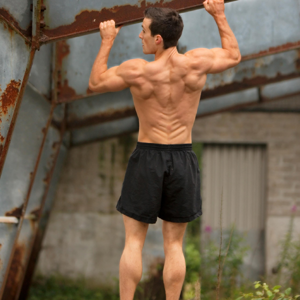 Scott Baptie doing pull ups while shirtless looking ripped and muscular