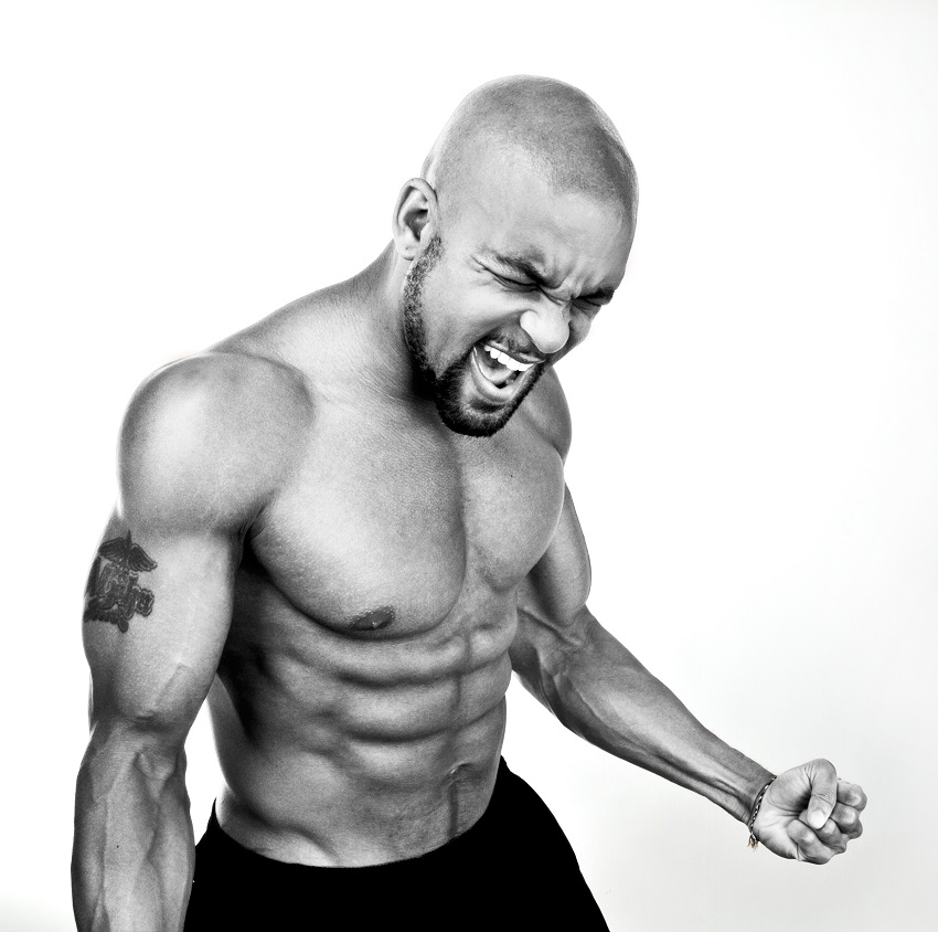 Shaun T flexing his muscles and yelling in a photo shoot