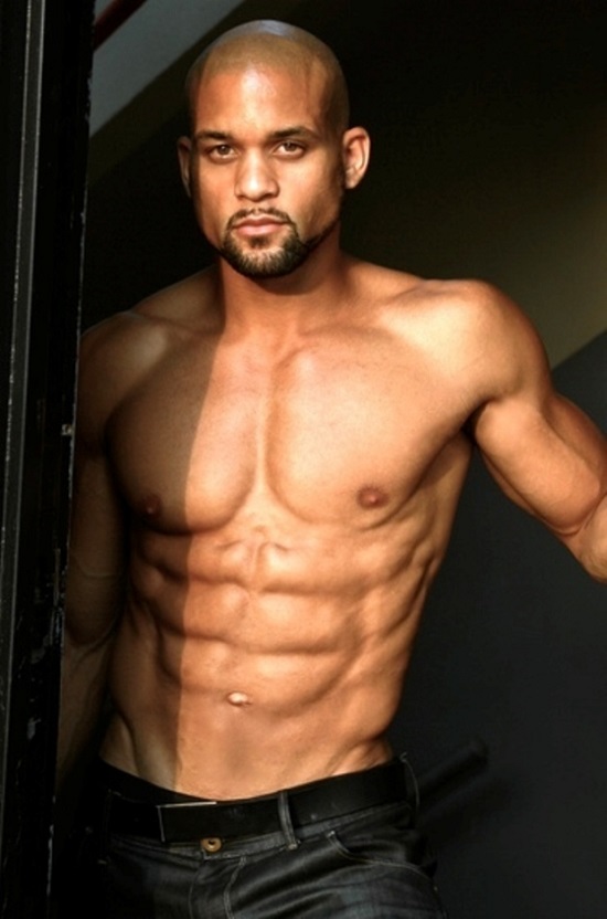 Shaun T posing shirtless for a photo looking strong and lean