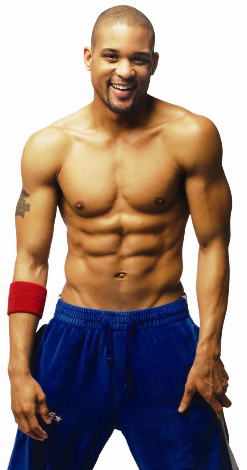 Shaun T posing shirtless showing off his lean and fit physique