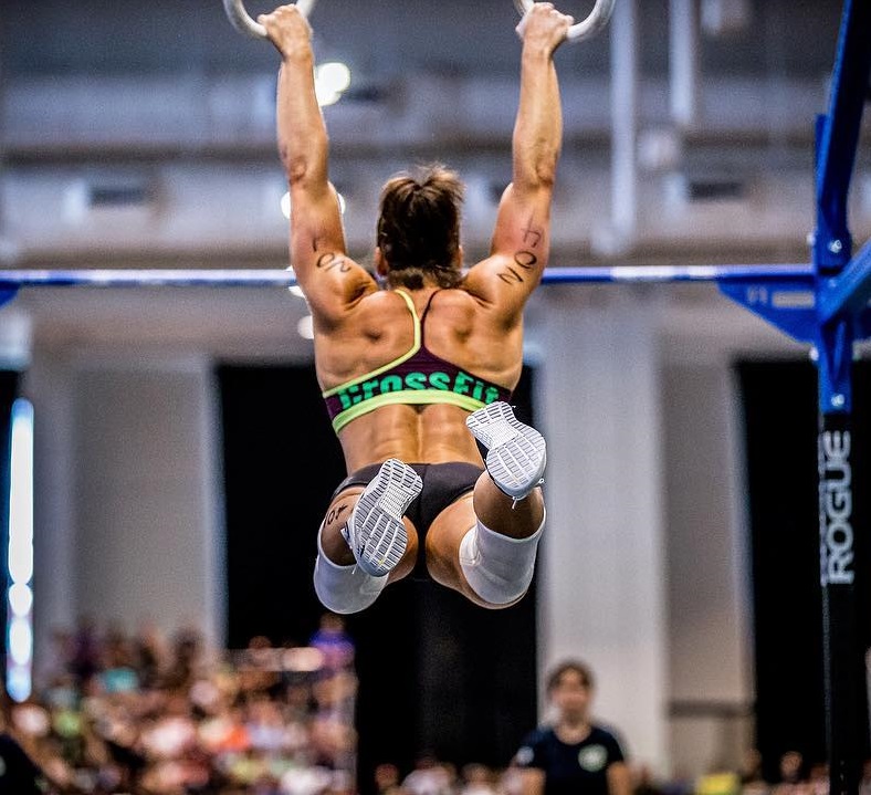 Stacie Tovar doing CrossFit exercise in front of a full room of people