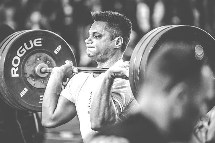 Travis Williams lifting heavy barbell during a CrossFit contest